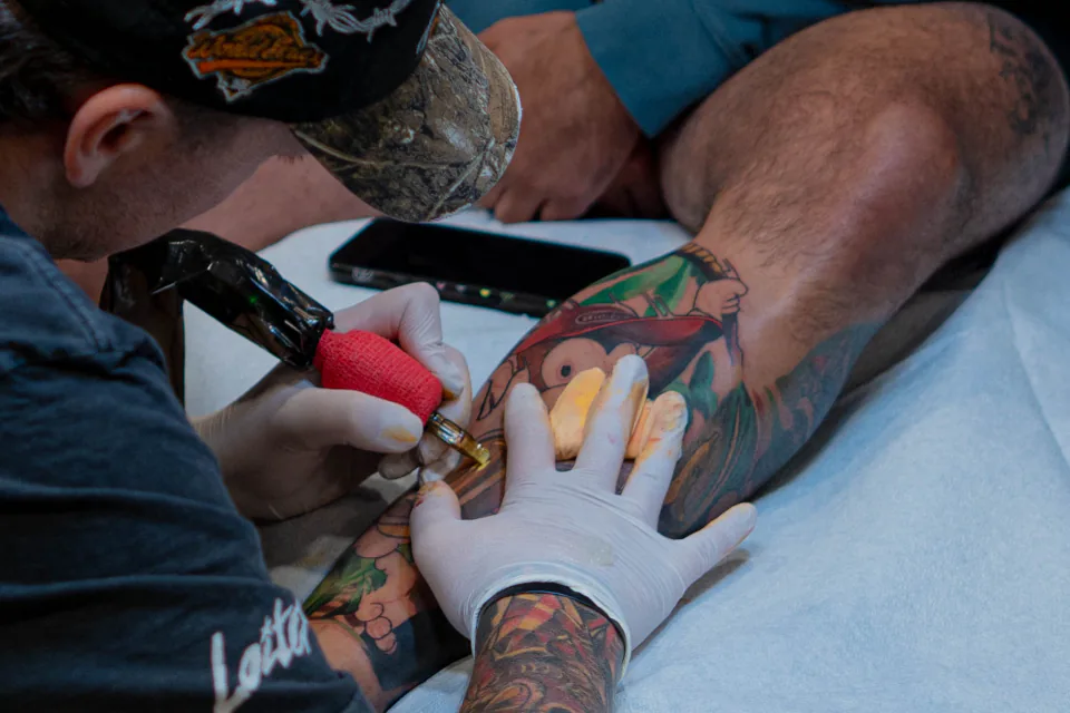 Tattoo artist working during a color tattoo session